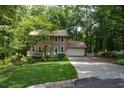 House exterior showcasing a manicured lawn and wooded surroundings at 4848 Green Forest Nw Ct, Acworth, GA 30102