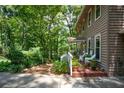 Side porch with white railings, potted plants, and wooded backdrop at 4848 Green Forest Nw Ct, Acworth, GA 30102