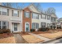 Two story townhome with brick and siding exterior, teal accents, and landscaping at 3712 Berkeley Xing, Duluth, GA 30096