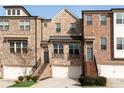 Attractive brick townhome featuring a two-car garage, multiple windows and landscaped entryway at 4139 Torver Ln, Atlanta, GA 30341