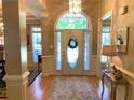 Bright foyer boasts hardwood floors, a decorative rug, and a beautiful front door with sidelights and transom window at 517 Mary Margaret Walk, Loganville, GA 30052