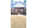 Charming brick home with a cozy front porch and meticulously maintained landscaping leading to the entryway at 517 Mary Margaret Walk, Loganville, GA 30052