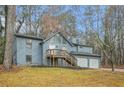 Gray sided two story house with a deck, two car garage, and large yard at 4006 Maxanne Nw Dr, Kennesaw, GA 30144