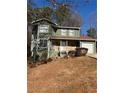 Two-story green house with stone accents and a red roof at 5250 Mountain Village Ct, Stone Mountain, GA 30083