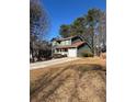 Green two-story house with attached garage and driveway at 5250 Mountain Village Ct, Stone Mountain, GA 30083