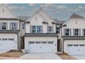 Townhouse with white brick exterior, gray shutters, and white garage doors at 4160 Cavalier Way, Duluth, GA 30097