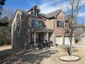 View of the brick home with an attached two-car garage and well maintained landscaping at 4417 Green Pastures Way, Ellenwood, GA 30294