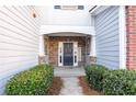 Welcoming front entrance with stone accents and lush landscaping at 704 Woodland Pl, Woodstock, GA 30188