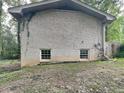 Brick rear exterior with two basement windows at 4048 Rainbow Dr, Decatur, GA 30034
