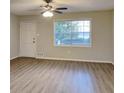 Bright living room features new laminate floors, a ceiling fan, and a large window at 1581 Wesley Nw Way, Conyers, GA 30012