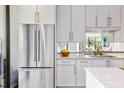 A modern kitchen featuring stainless steel refrigerator, white cabinets, and marble countertop at 2575 Peachtree Ne Rd # 6G, Atlanta, GA 30305