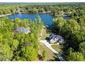 Overhead view of a beautiful lakeside home surrounded by mature trees and manicured lawn at 45 Kinloch Ct, Covington, GA 30014