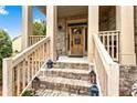 Front entrance with stone steps and wooden door at 1114 Ivey Chase Pl, Dacula, GA 30019