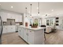 Open concept kitchen with white cabinets, island, stainless steel appliances, and hardwood floors at 24 Jacobs Farm Ln # 12, Loganville, GA 30045