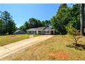 Spacious property featuring a long driveway, lush lawn, and mature trees at 780 Navajo Trl, Covington, GA 30016