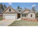 New single-story home with a two-car garage, landscaping, and a light beige exterior at 215 Eryn Ter, Covington, GA 30014