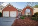 Brick ranch home with two-car garage and manicured landscaping at 4976 Centennial Hill Walk Nw Dr, Acworth, GA 30102