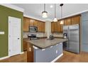 Well-equipped kitchen features stainless steel appliances, wooden cabinets, and island with counter seating at 2935 Maple Park Pl # 49, Cumming, GA 30041