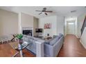 Bright living room with fireplace, modern ceiling fan, wood floors, and gray sectional sofa at 2725 Morgan Glen Rd, Buford, GA 30519