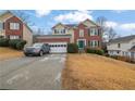 Front view of a two-story brick house with a driveway at 1155 Carlysle Park Dr, Lawrenceville, GA 30044