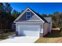 Two-car garage with white doors and stone accents at 40 Eryn Ter, Covington, GA 30014