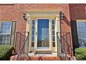 Close-up of the front door with sidelights, detailed trim, and wrought iron railing at 1150 Cedar Bluff Sw Trl, Lilburn, GA 30047