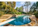 Beautiful in-ground pool with diving board, stone surround, and lounge chairs at 510 Newport Trce, Alpharetta, GA 30005