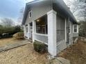 View of the charming bungalow showing the front porch, siding, and landscaping at 1790 Spring Ave, East Point, GA 30344
