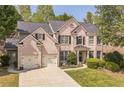 Two-story brick home with a manicured lawn and a two-car garage offers great curb appeal in a desirable location at 6615 Hampton Rock Ln, Cumming, GA 30041