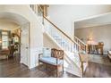 Spacious foyer with hardwood floors, staircase, and bench seating; entry to living area with nice natural light at 6615 Hampton Rock Ln, Cumming, GA 30041