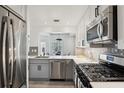 Modern kitchen featuring stainless steel appliances, gray cabinets, and an open layout at 220 Renaissance Pkwy # 1203, Atlanta, GA 30308