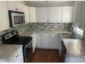 Galley-style kitchen with white cabinets, granite countertops, and stainless steel appliances at 2351 Johnson Ferry Ne Rd, Chamblee, GA 30341