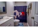Cozy bathroom featuring a vibrant shower curtain and a white vanity at 1469 Harmony Grove Church Rd, Auburn, GA 30011
