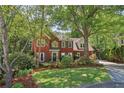 Charming brick home with lush landscaping, mature trees, and a well-maintained lawn at 959 Cedar Falls Sw Ct, Lilburn, GA 30047