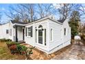 A stone walkway leading to a home with white siding, black trim and a dark shingled roof at 1380 Westmont Sw Rd, Atlanta, GA 30311