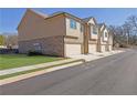 Side view of townhomes showcasing attached garages and brick accents at 4131 Fulson Dr, Lilburn, GA 30047