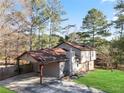 Exterior elevation with carport, stone and siding, and mature trees at 2492 Crumps Landing Cir, Snellville, GA 30039