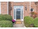 Front door with glass and black hardware, flanked by lush greenery and a 'Welcome' mat at 2107 Kendall Close Nw, Acworth, GA 30102