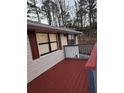 Red painted deck highlighting the exterior features, with a railing and shutters at 3566 Carry Ct, Snellville, GA 30039