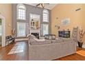 Two-story living room with hardwood floors, fireplace, and large windows at 1553 Rolling Meadows Dr, Mcdonough, GA 30253
