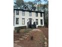 Two story home with white siding and black accents, landscaped yard, and stone pathway at 911 David Dr, Lawrenceville, GA 30046
