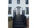 Elegant front entrance with black door and stairs, framed by black trim and landscaping at 911 David Dr, Lawrenceville, GA 30046