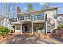 Back exterior view with patio, hot tub, spiral staircase, and outdoor access at 213 Pine Crest Dr, Cumming, GA 30040