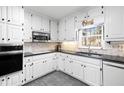 Well-lit kitchen features white cabinets, granite countertops, and stainless steel appliances at 3521 Southern Bay Ct, Snellville, GA 30039