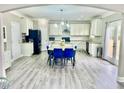 Open kitchen design with white cabinets, grey floor, and a large center island adjacent to a dining table at 4850 Wilshire Xing, Cumming, GA 30040