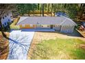 Well-kept single-story home displaying a spacious driveway, green lawn, and a mix of brown and gray exteriors at 681 Fielding Sw Ln, Atlanta, GA 30311