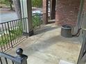 Outdoor patio area featuring brick walls, iron railings, and an air conditioning unit at 3091 Colonial Way # C1, Atlanta, GA 30341