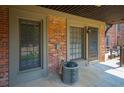 Outdoor patio area featuring brick walls, two large windows, and an air conditioning unit at 3091 Colonial Way # C1, Atlanta, GA 30341