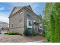 Side view of a three-story townhome showcasing brick exterior and landscaping at 4249 Tacoma Trce, Suwanee, GA 30024