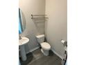 Powder room featuring a pedestal sink, gray walls, and gray wood-look flooring at 3306 Loblolly Pine Way, Decatur, GA 30034